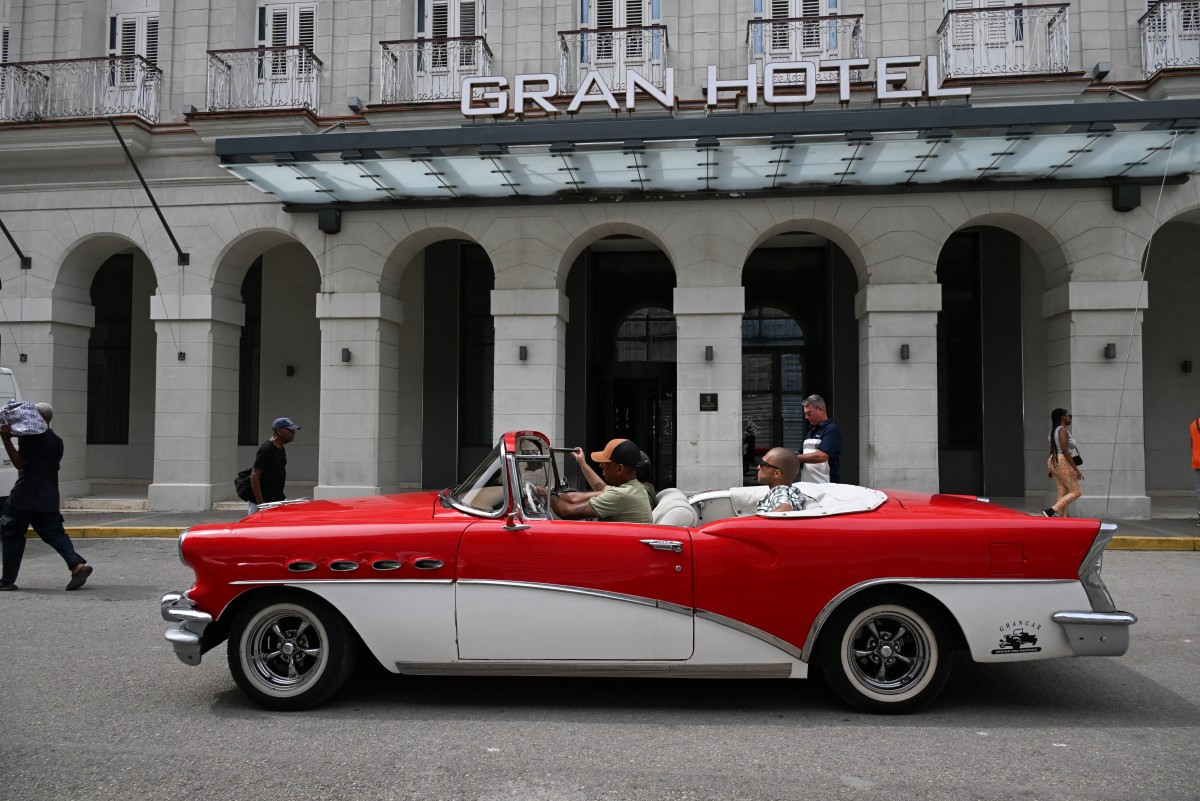 An old car drives past the Gran Hotel Bristol in Havana, Cuba. (AFP)