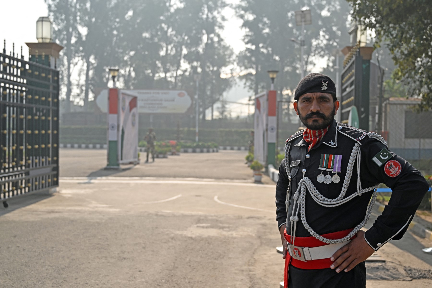 Pakistan's paramilitary personnel (R) and India's border security personnel stand guard at the Kartarpur Sahib Corridor along the India-Pakistan border in Kartarpur on November 19, 2024. (AFP)