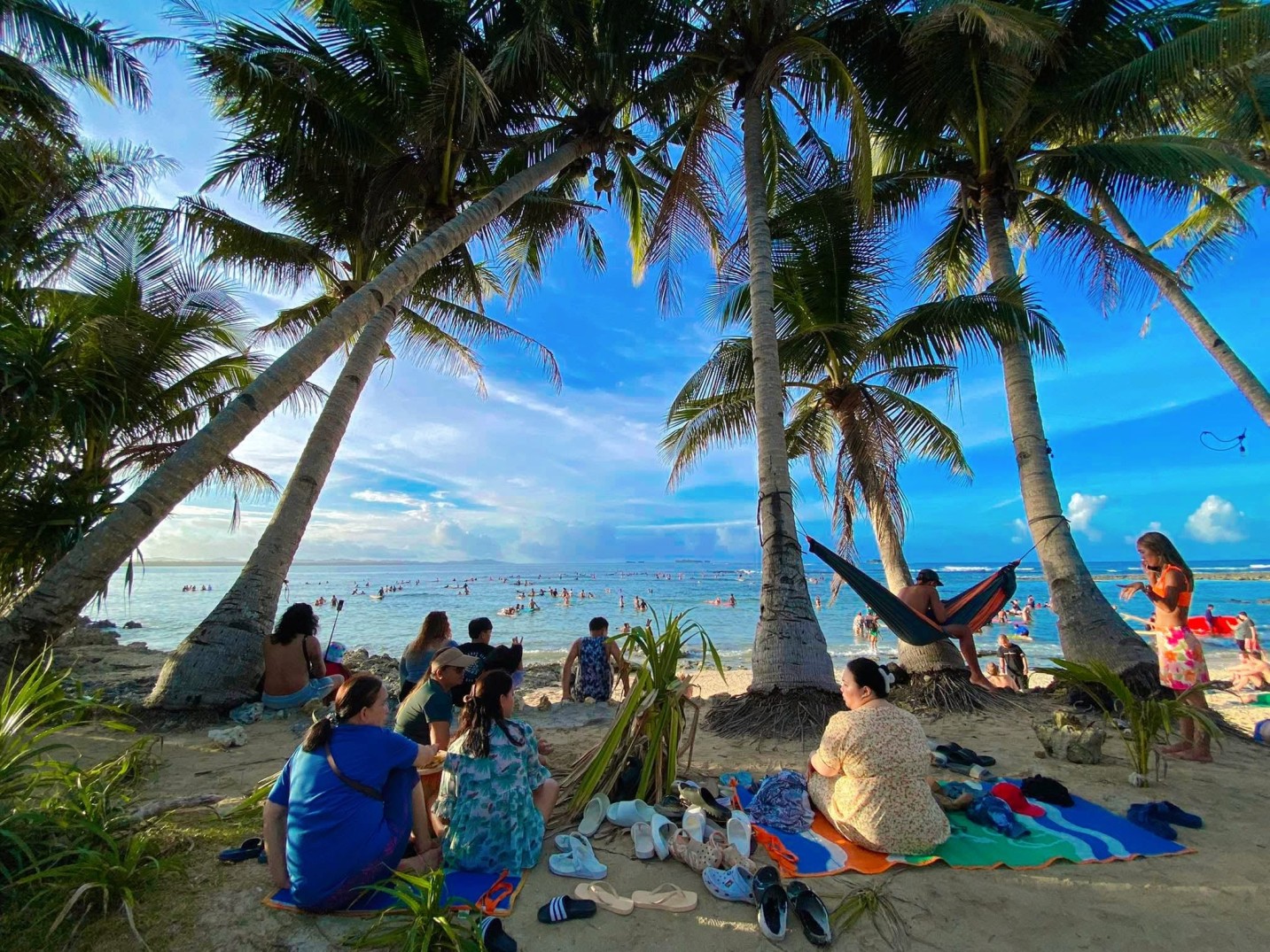 Visitors sit at the beach on the popular Cloud 9 surfing spot on Siargao island, the Philippines on March 28, 2024. (General Luna Tourism Office)