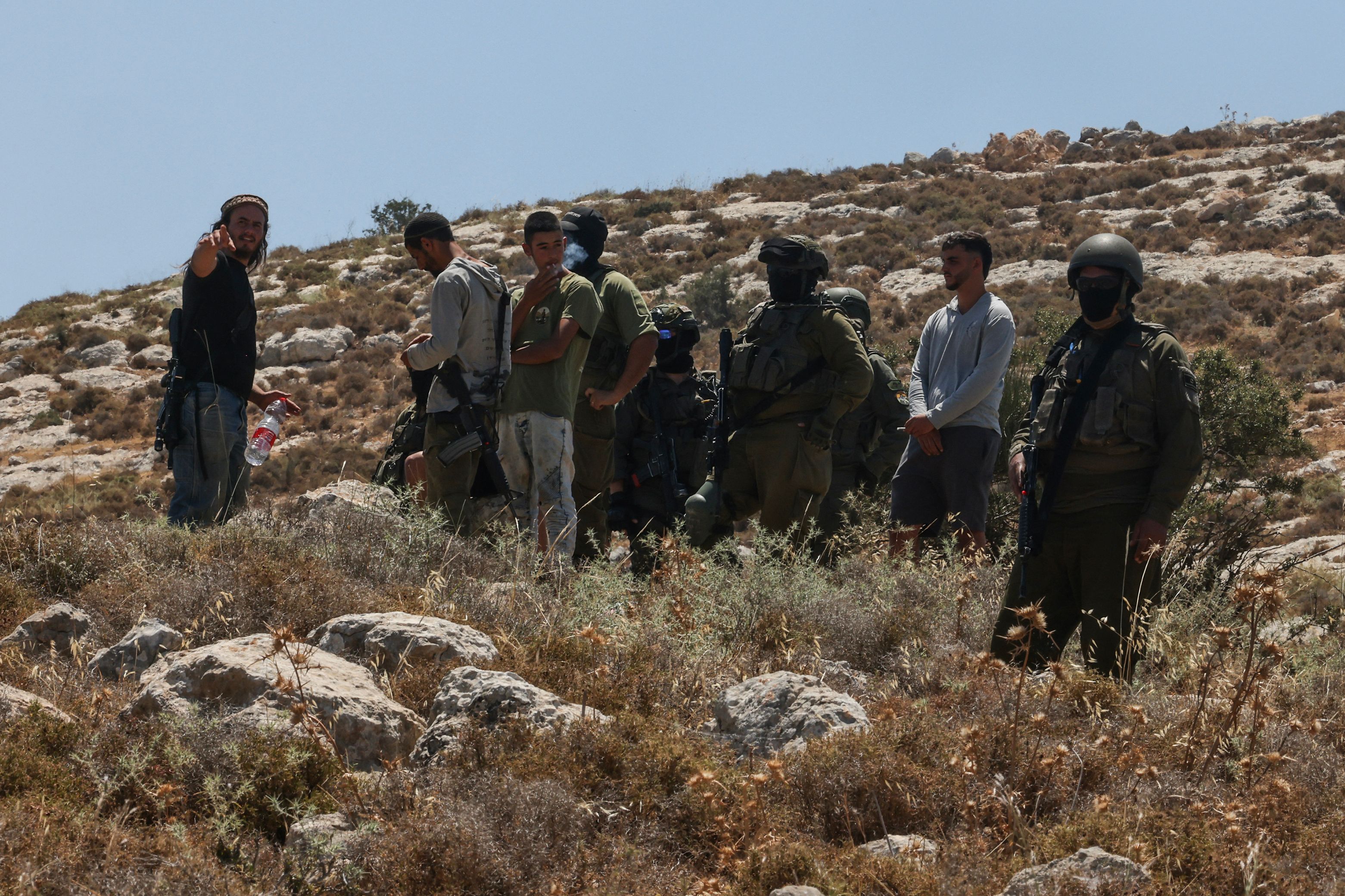 Image Caption : Israeli forces and armed settlers guard a bulldozer reportedly operating on Palestinian lands as local Palestinian landowners (unseen) gather in protest against land confiscations near the village of Dura, west of Hebron in the Israeli-occupied West Bank, on June 9, 2026. (AFP)