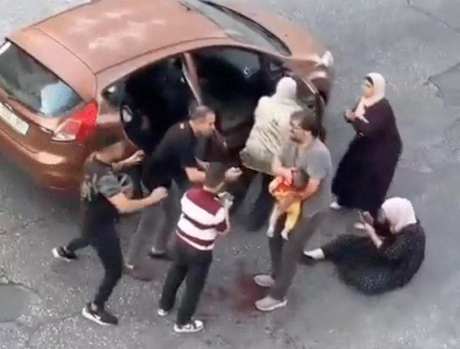 A video screengrab shows seven-month-old Sam Abu Haikal being carried by his father moments after an Israeli soldier shot at the car they were traveling in, in Hebron on June 5, 2026. (B’Tselem via Reuters)
