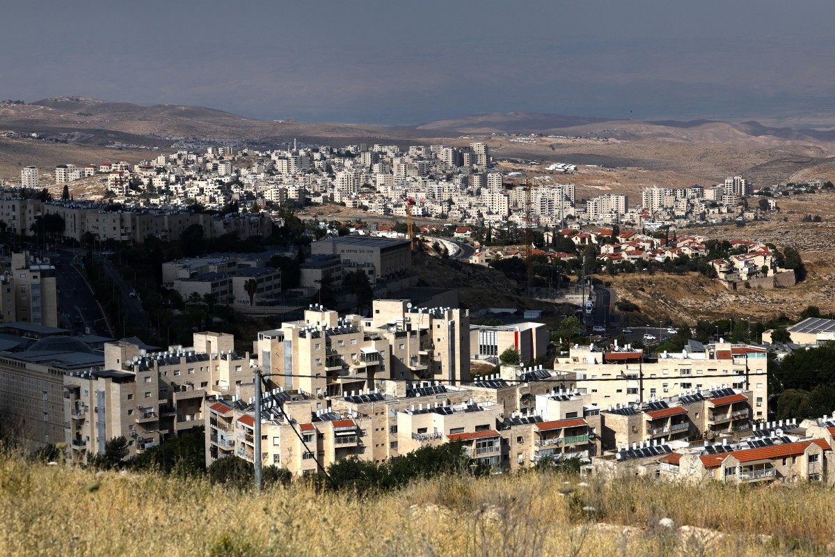 The Israeli settlement of Pisgat Zeev (foreground) in the northern area of east Jerusalem and Israel's controversial barrier separating the Palestinian town Hzma (background) are pictured in the occupied West Bank on May 22, 2026. (File/AFP)