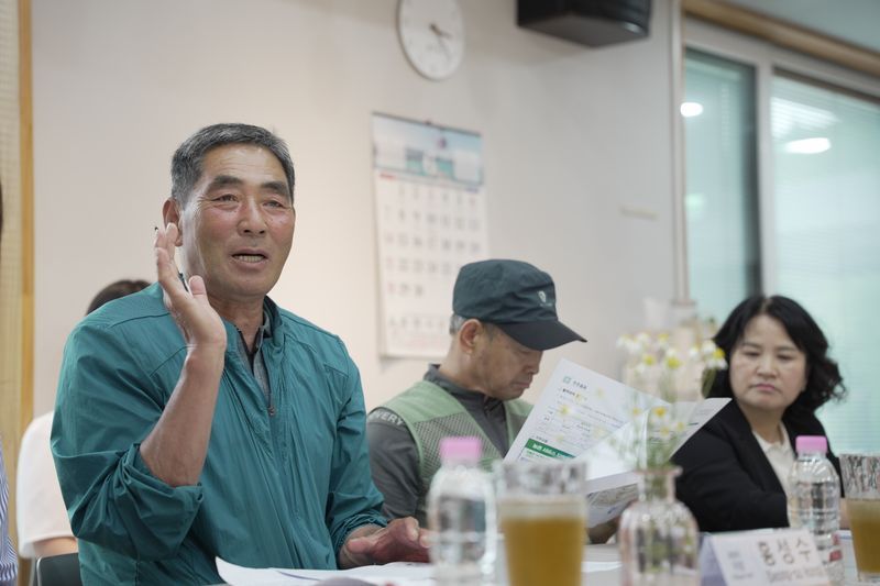Songam-ri village chief Seong-su Hong speaks to the international press about the Sunshine Income Village scheme. (Supplied)