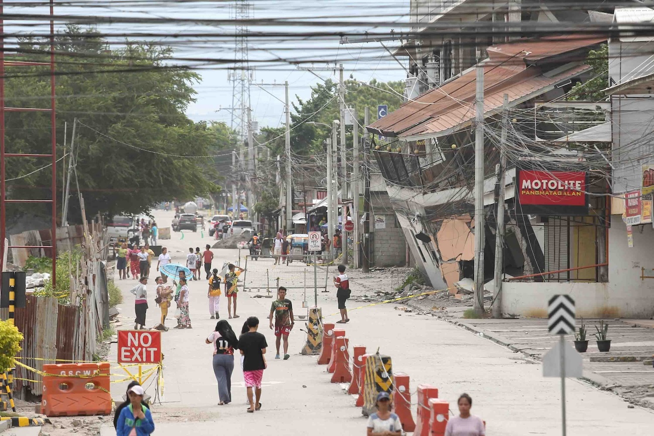 People walk past a collapsed building following an earthquake in Sarangani province, Philippines Wednesday, June 10, 2026. (AP)