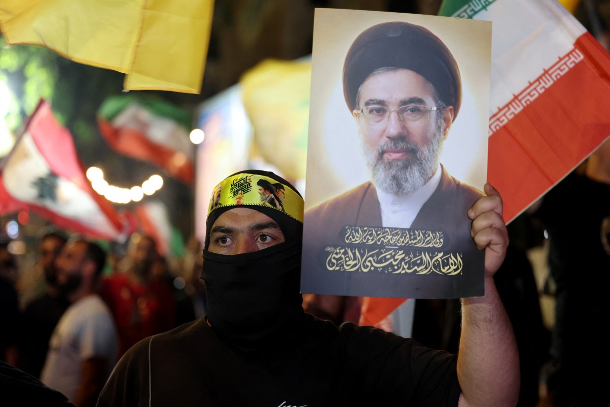 A supporter of Iran-backed armed group Hezbollah, holds a portrait of Iran’s supreme leader Mojtaba Khamenei during an anti-US and anti-Israel protest organised by the International Popular Committees to Resist Aggression in Beirut’s southern suburbs. (AFP)