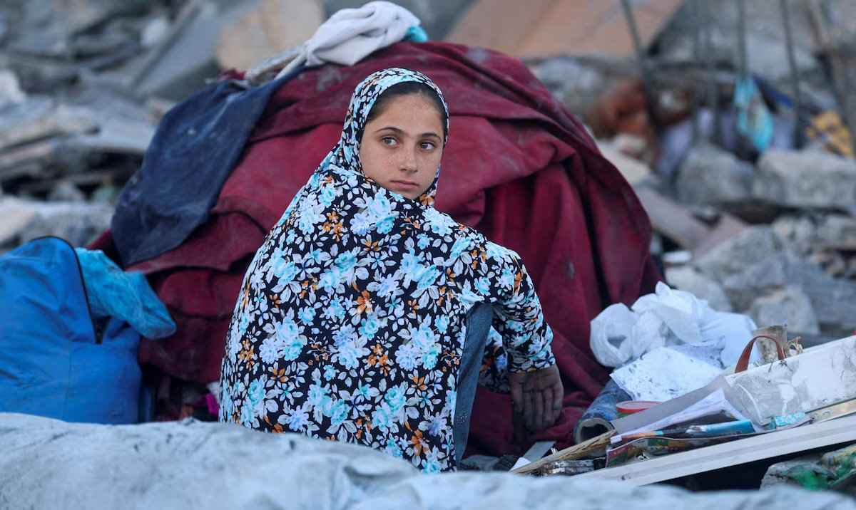 A Palestinians girl sits at the site of an Israeli strike on a house whose residents were warned to evacuate before the attack, near a tent camp sheltering displaced people that was damaged in the strike, in Khan Younis in the southern Gaza Strip June 7, 2026. (Reuters)