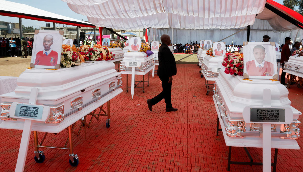 A man walks next to the caskets of the victims of an overnight dormitory fire at the Utumishi Girls Academy Senior School, during a memorial service in Gilgil, Nakuru county, Kenya on June 12, 2026. (Reuters)