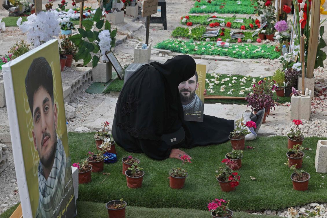 Above, Ghada Hussein mourns over the grave of her son Mohammed Tufayli, a Hezbollah fighter, at a temporary cemetery in the southern coastal Lebanese city of Sidon on June 11, 2026. (AFP)