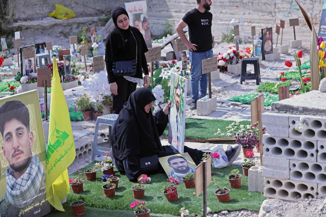 Ghada Hussein (C) mourns over the grave of her son Mohammed Tufayli, a Hezbollah fighter who was killed during the ongoing war, at a temporary cemetery in the southern coastal Lebanese city of Sidon on June 11, 2026. (AFP)