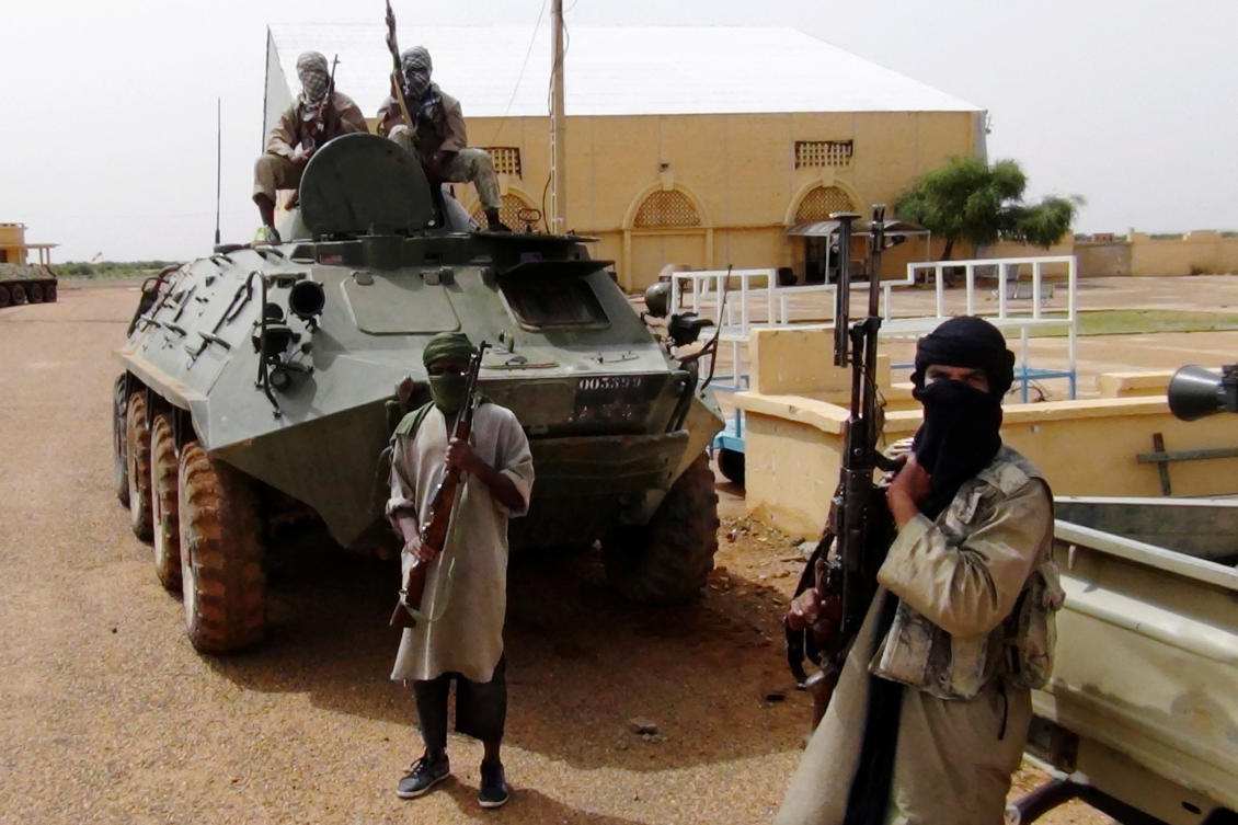 Fighters from the Al Qaeda-linked Islamist group MUJWA, who are travelling with a convoy including Burkina Faso foreign minister Djibril Bassole, stand guard in Gao, northern Mali, August 7, 2012. REUTERS/Stringer/File Photo