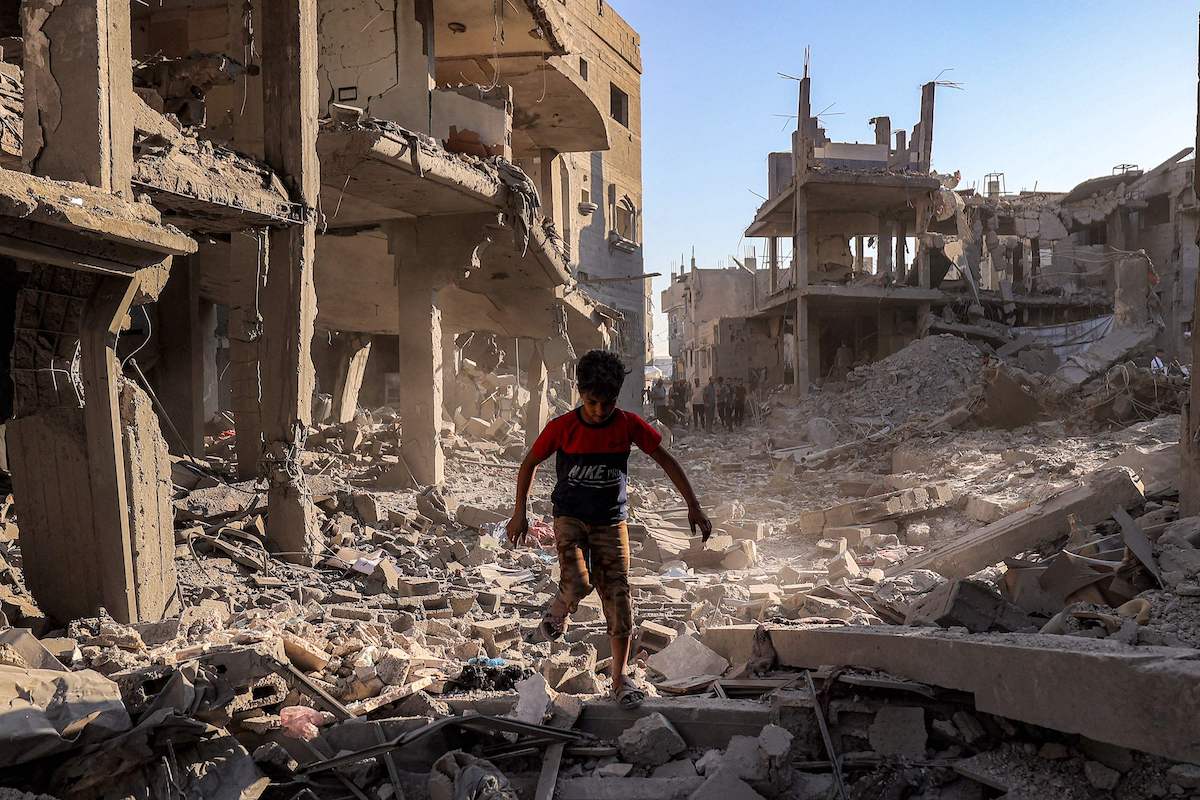A boy walks through the rubble of a building that was destroyed by Israeli bombardment after an evacuation order, at the Maghazi camp for Palestinian refugees in the central Gaza Strip on Friday. (AFP)