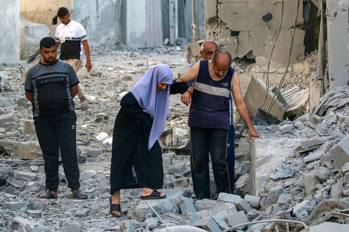 A man helps a woman walk through the rubble of a building that was destroyed following Israeli bombardment after an evacuation order, at the Maghazi camp for Palestinian refugees in the central Gaza Strip, June 12, 2026. (Eyad Baba/AFP)