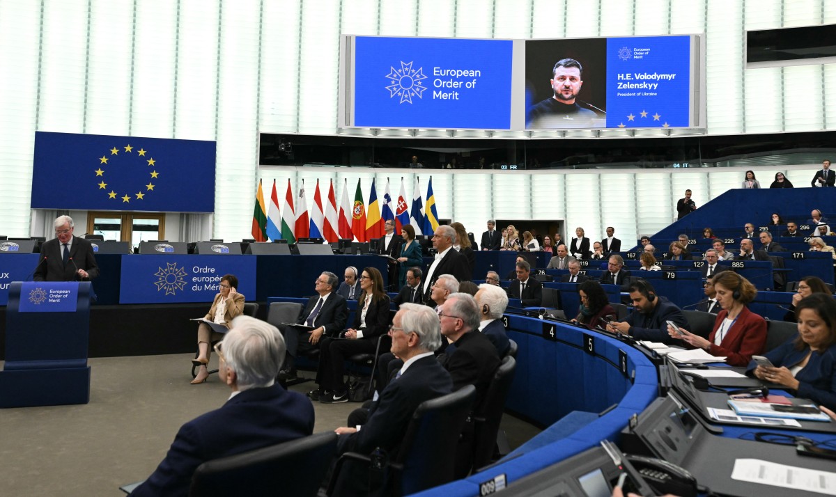 Ukrainian President's Zelenskyy's photo displayed during a ceremony honoring him to receive European Order of Merit at the European Parliament's hemicycle in Strasbourg, France. (AFP)