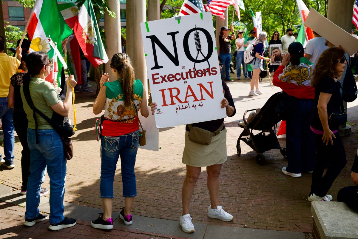 Demonstrators hold signs as they gather near the Francis Scott Key Bridge during rally in support of the Iranian people in Washington, US. (AFP)