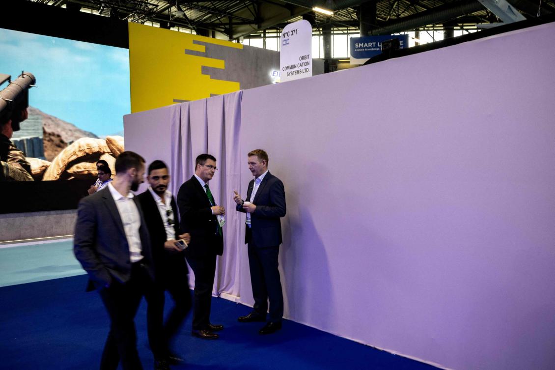Visitors walk by the closed stand of Israeli airborne and maritime communications, satellite tracking, and ground-station technology company Orbit Communication Systems at the Eurosatory land and airland defence and security trade fair, at the Paris-Nord Villepinte Exhibition Centre in Villepinte, north of Paris on June 15, 2026. (AFP)