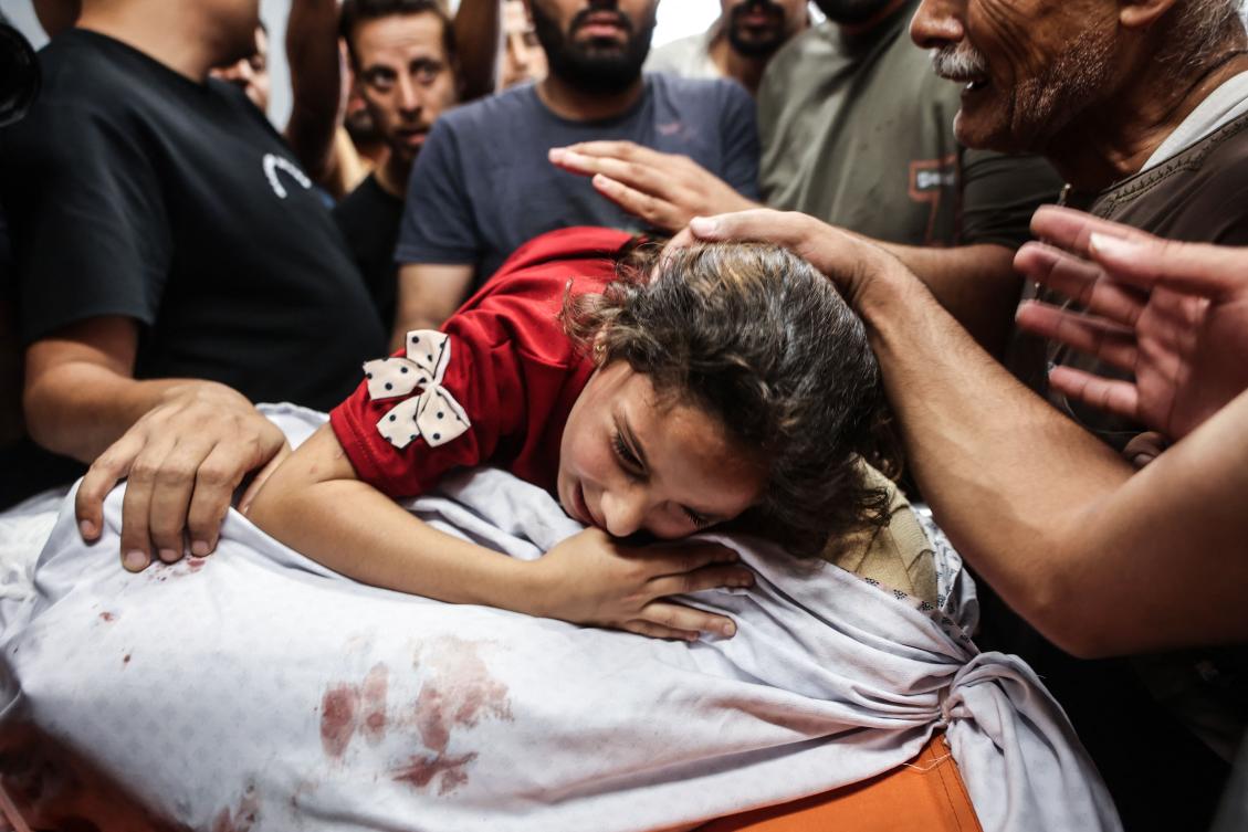 Zeina Al-Habil hugs the body of her father after he and her 5-year-old brother were killed in an Israeli missile strike that targeted their home in Gaza's Sheikh Radwan neighborhood on Monday. (AFP)