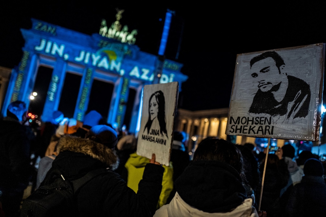 Activists display placards featuring portraits of recently executed Iranian demonstrator Mohsen Shekari and Kurdish woman Mahsa Amini who died in police custody, during a demonstration in support of demonstrators in Iran, in front of the Brandenburg Gate, Germany. (AFP)