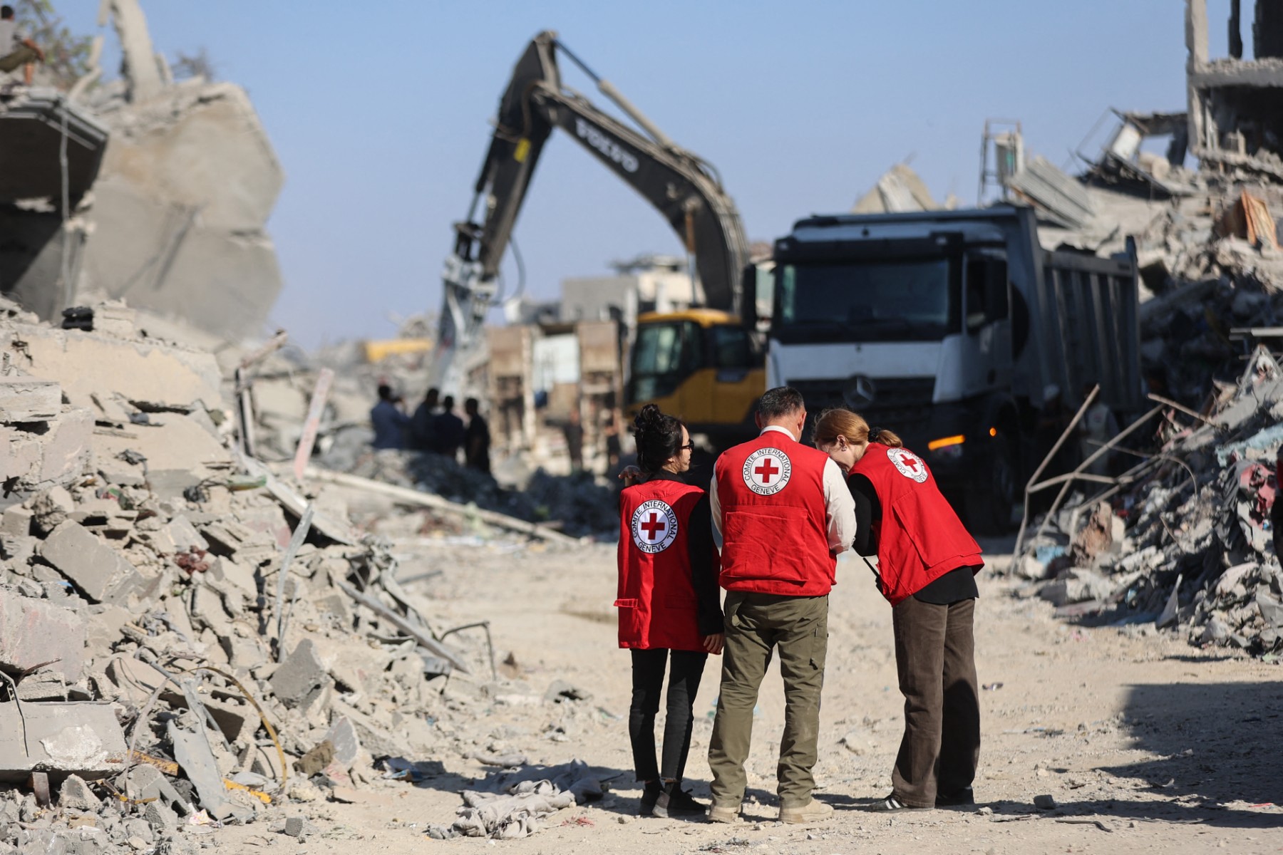 Members of the Red Cross stand amid the rubble of destroyed buildings as heavy machinery operates in the al-Tuffah neighbourhood of Gaza City, Oct. 27, 2025. (Files/AFP)