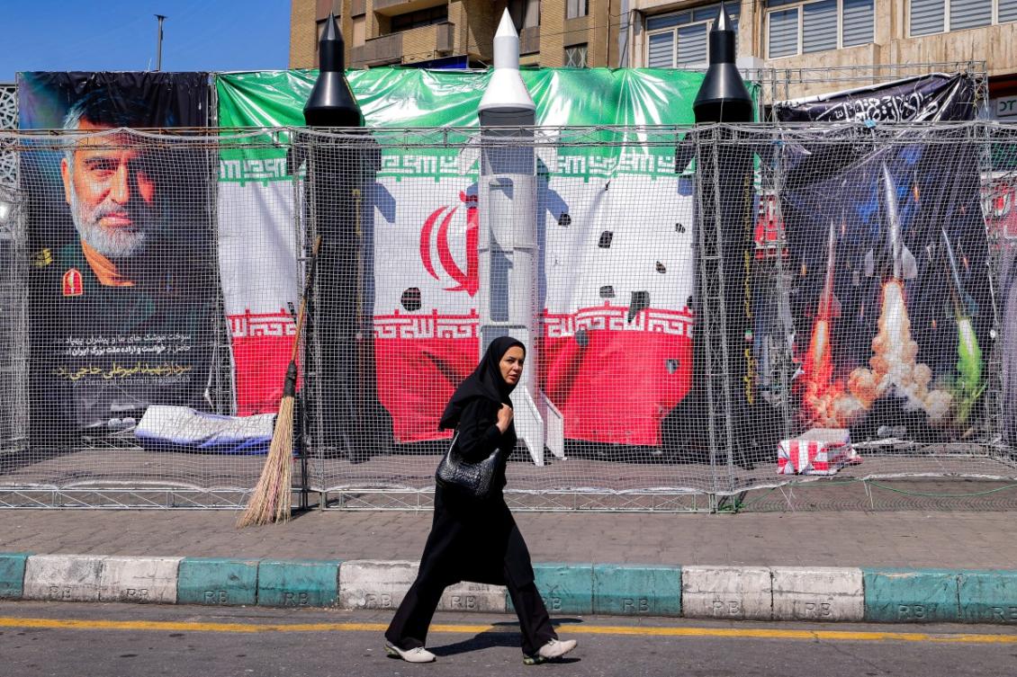 Above, a woman walks past mockups of Iranian missiles along Valiasr Square in Tehran on April 6, 2026. (AFP)