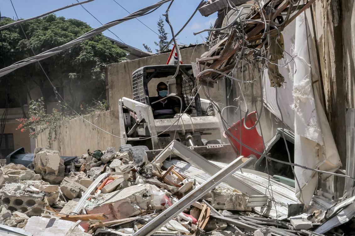 A worker pilots a small excavator to remove the rubble of a destroyed building in the village of Deir Qanoun Al-Nahr in southern Lebanon on Jun. 16, 2026.(AFP)