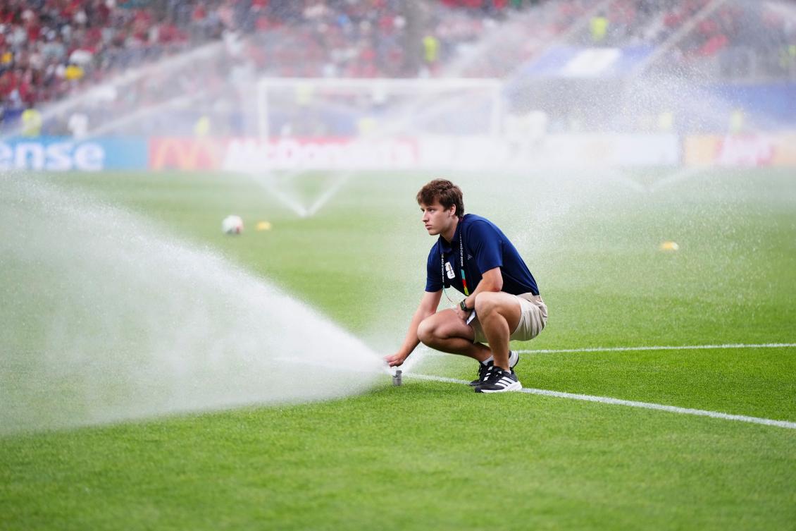 A grounds crew member directs water onto the grass before the World Cup Group K match between Portugal and Congo in Houston, Jun. 17, 2026. (AP)