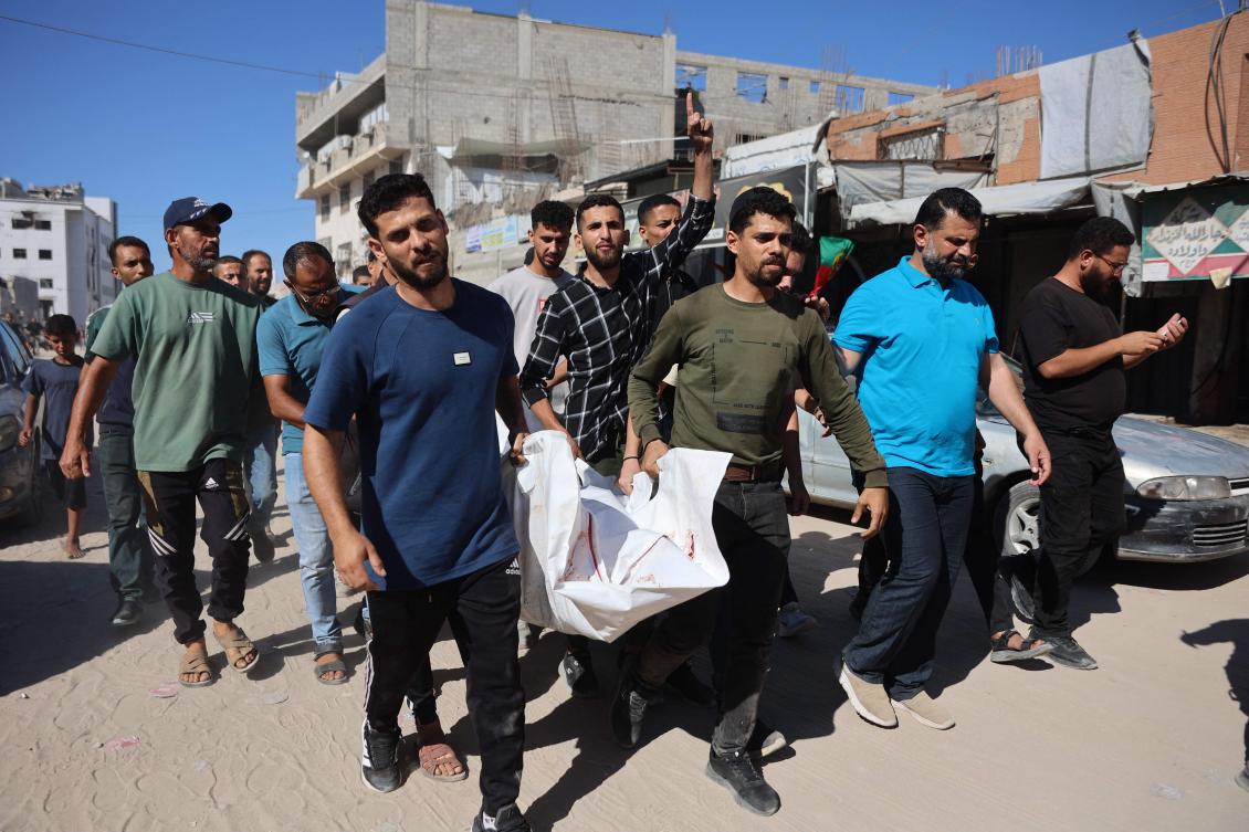 Displaced Palestinians carry the body of a man killed in an Israeli airstrike for burial from the Al-Shifa Hospital in Gaza City, on June 18, 2026. (AFP)