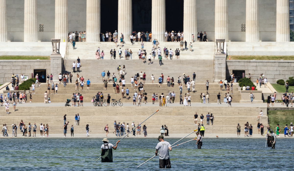 National Park Service workers and contractors use vacuums to remove algae from the bottom of the Lincoln Memorial Reflecting Pool on June 20, 2026 in Washington, DC. (AFP)