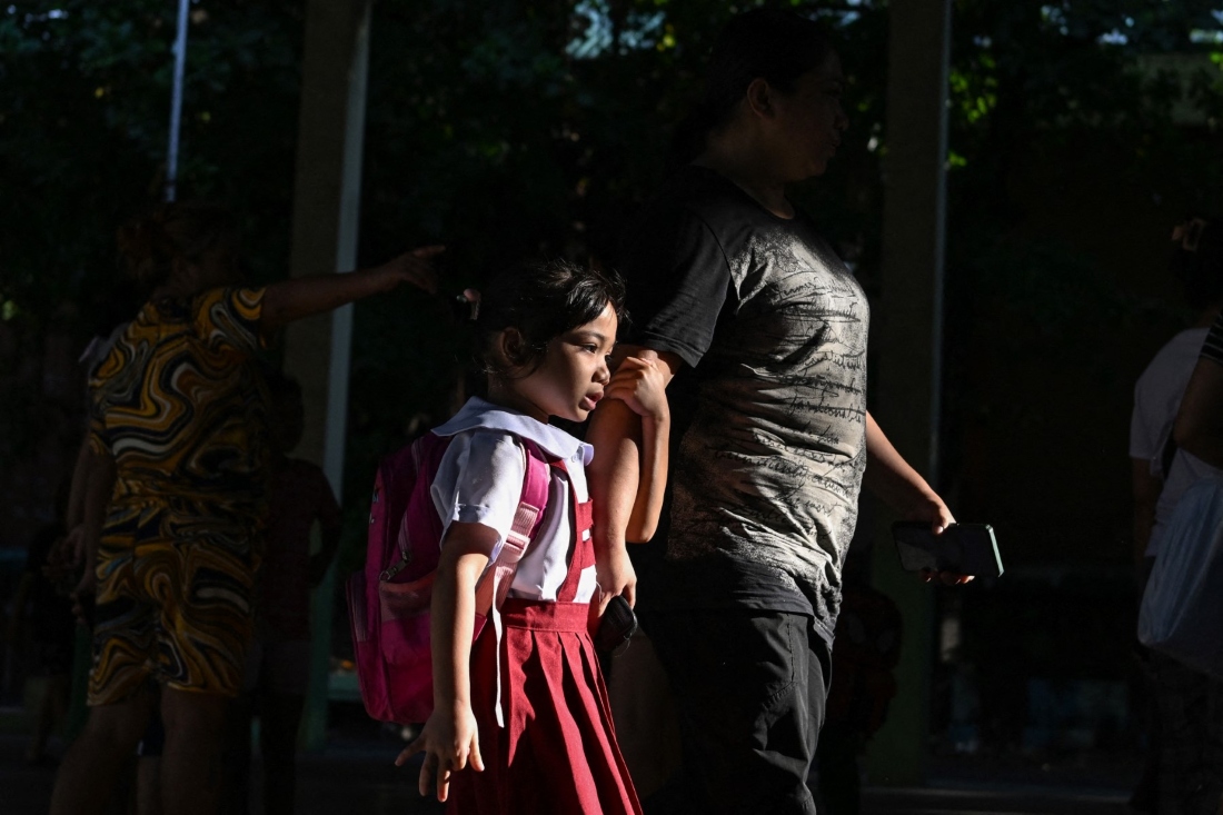 A parent accompanies a student as classes open for the new school year at an elementary school in Manila, Philippines on June 16, 2025. (AFP)