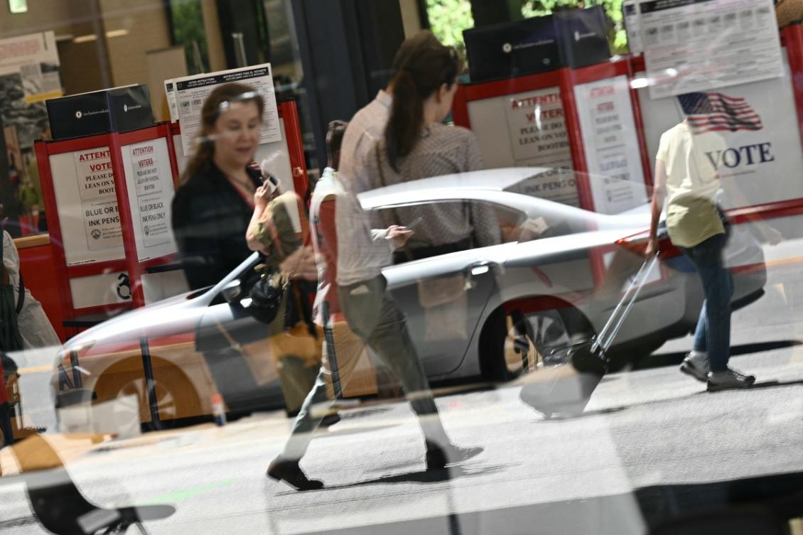 Above, people walk past at a polling place at the Martin Luther King Jr. Memorial Library during the DC primary elections on June 16, 2026 in Washington, DC. (AFP)
