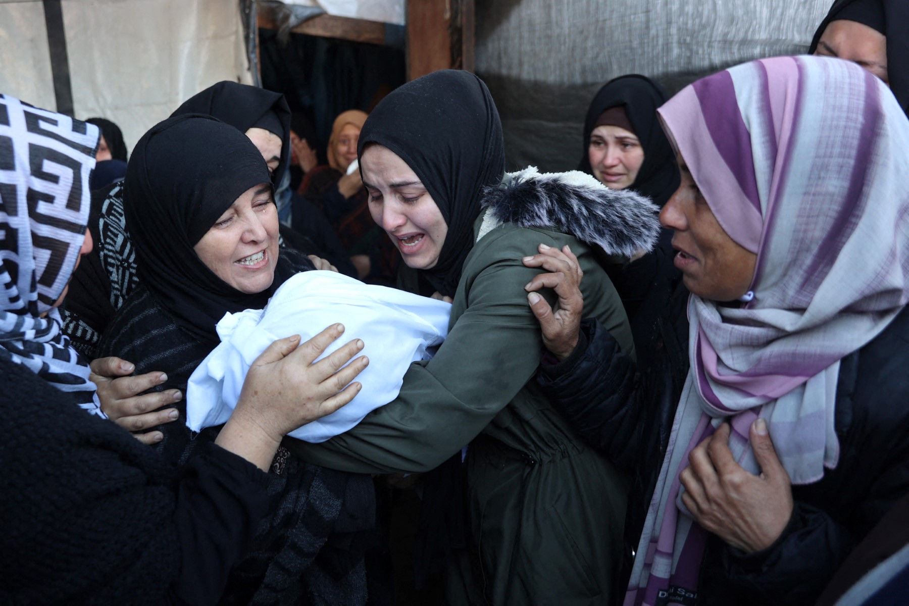 Palestinian women mourn a dead child, killed in an Israeli strike the previous night, at Al-Ahli Arab hospital in Gaza City on Dec. 21, 2024. (AFP file photo)