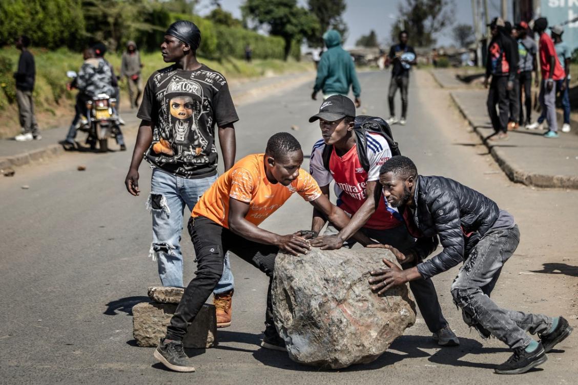 Above, protesters roll a large stone as they attempt to block a main road during a demonstration against a controversial US-built Ebola quarantine center slated to begin operations at Laikipia Air Base in Nanyuki on June 9, 2026. (AFP)