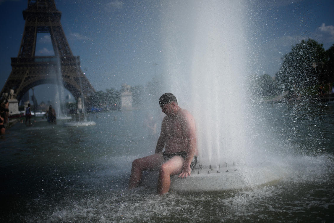 A person cools off at Trocadero fountain near the Eiffel Tower during a heat wave in Paris, Wednesday. (AP)