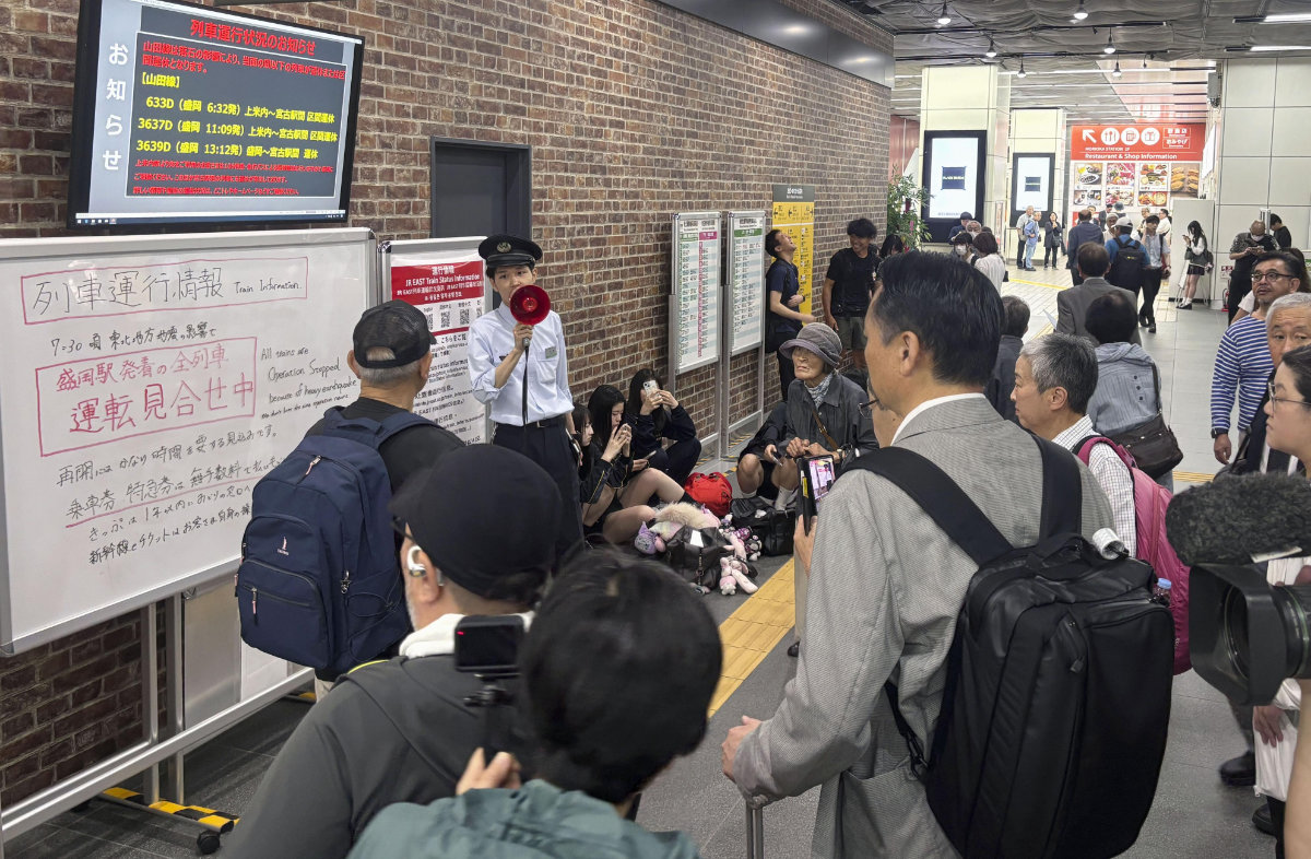 A station clerk of the East Japan Railway Co., provides an update about train services which were suspended due to an earthquake at JR Morioka station in Morioka, northern Japan, on July 25, 2026. (Kyodo News via AP)