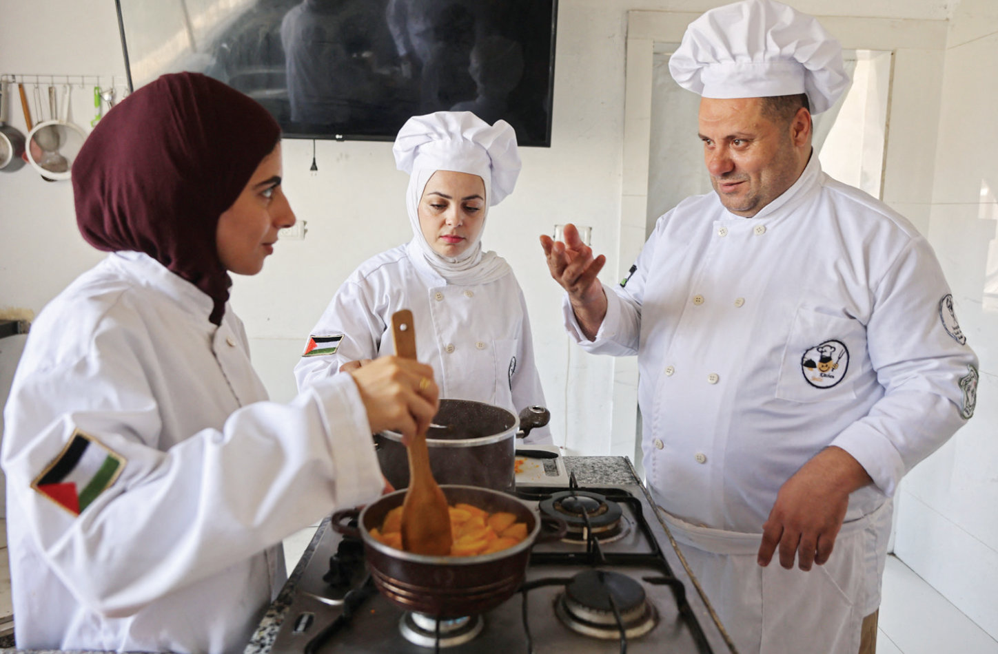 Nabil Al-Shawaf teaches students at the Smile Kitchen Academy in Gaza. (AFP)