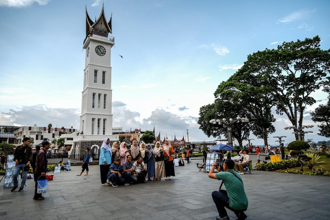 Visitors pose with Jam Gadang, an iconic tourist spot in West Sumatra, in the background in this photo posted on April 29, 2026. (Ministry of Tourism)