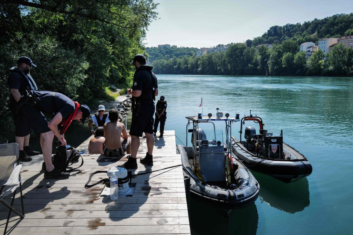 French National police and the river brigade controls a group of teenagers who were jumping off the Passerelle de la Paix bridge into the Rhone river, in Lyon, southern France, on Jun. 25, 2026 during a heatwave in France and Europe. (AFP)