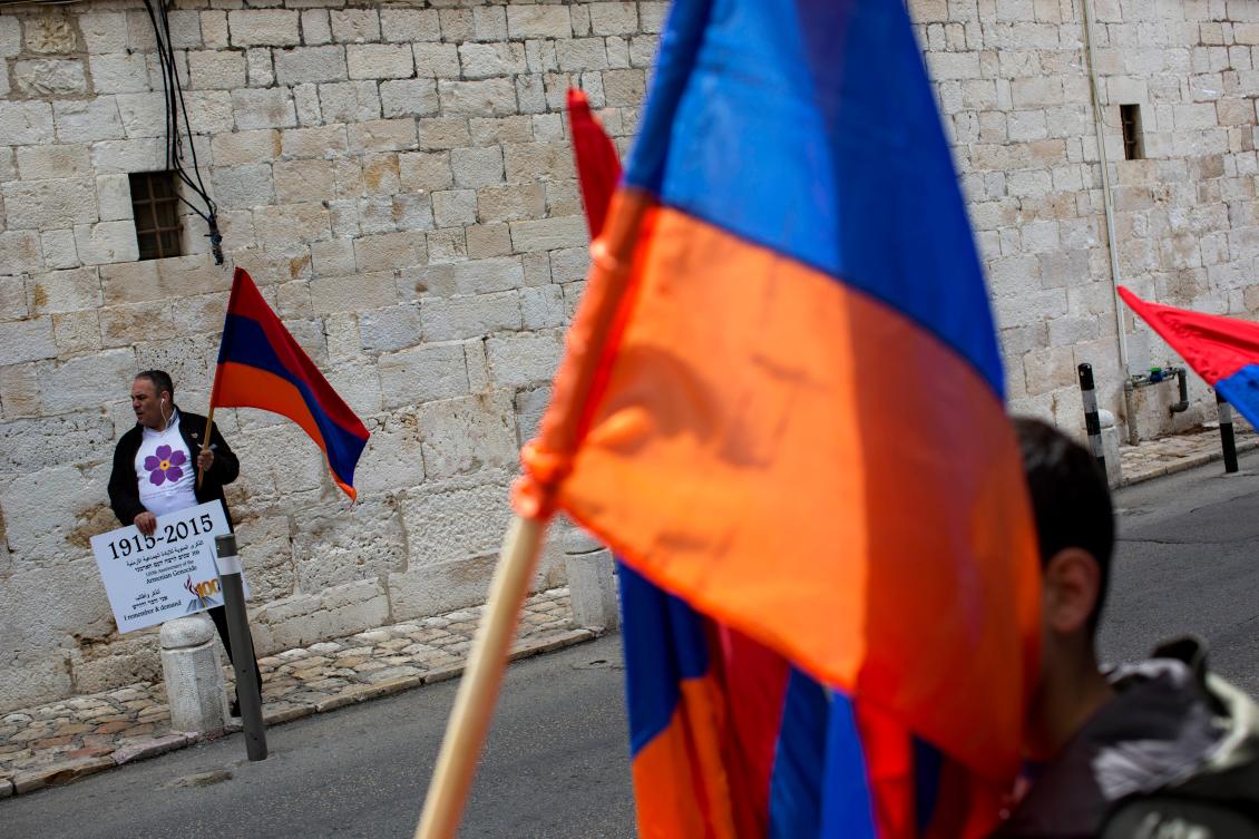 FILE - Armenians hold their national flag during a ceremony to commemorate the mass killings of Armenians by the Ottoman Empire, in Jerusalem, Israel, Friday, April 24, 2015. (AP Photo/Oded Balilty, File)