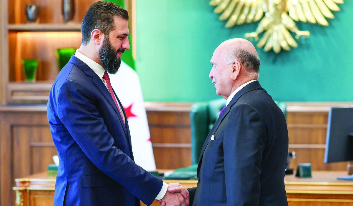 Syrian President Ahmad Al-Sharaa receives Iraqi Foreign Minister Fuad Hussein in Damascus on Monday. (AFP)