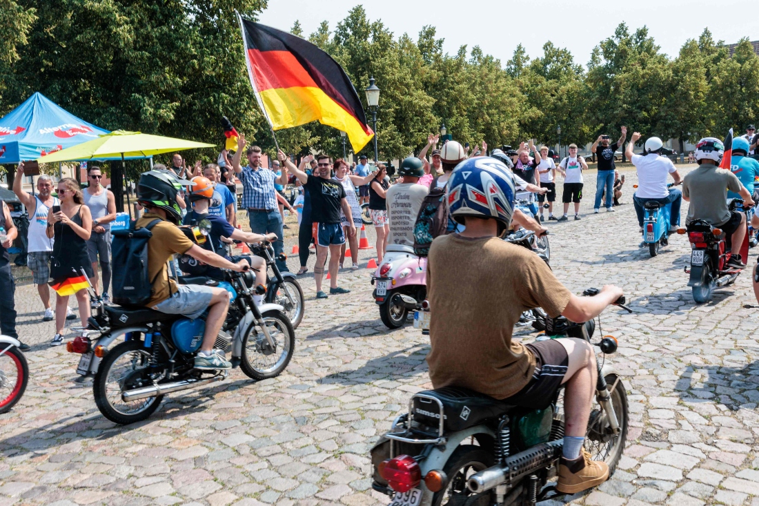 Supporters of far-right Alternative for Germany (AfD) party wave a German flag as they take part in an election campaign event and a motorbike and moped ride in Jessnitz, eastern Germany. (AFP)