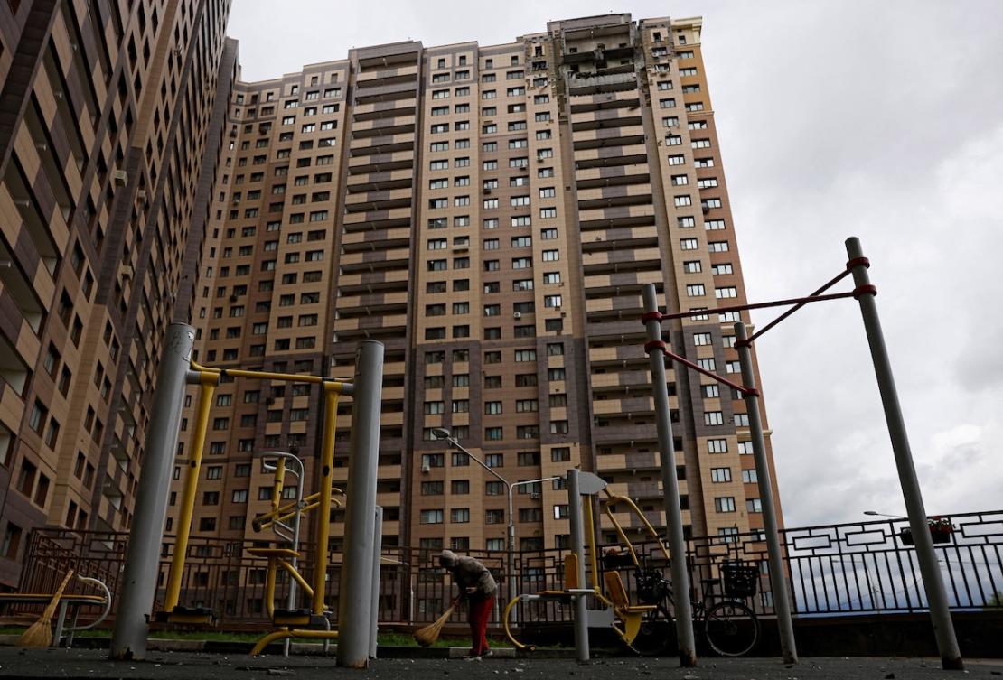 A person sweeps up debris in front of a damaged apartment building following an earlier Ukrainian drone attack in the Moscow region on June 18, 2026. (Reuters file photo)