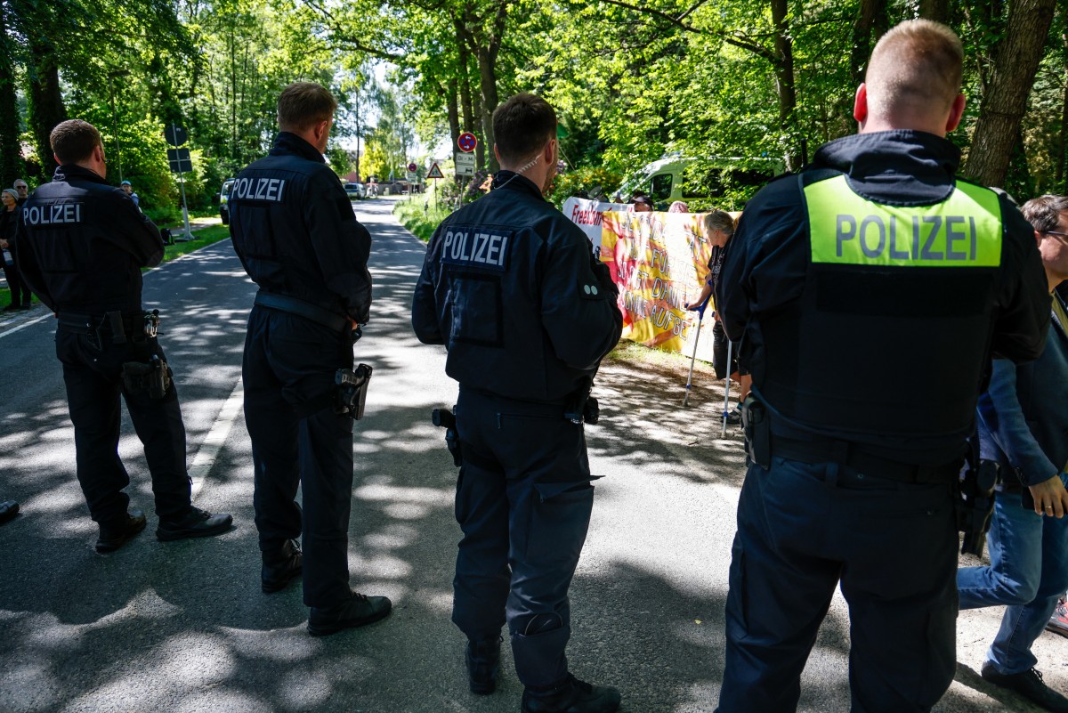 Police stand in front of supporters of Daniela Klette, former member of German far-left militant group The Red Army Faction (RAF), as they gather outside the Verden Regional Court for a continuation of the trial against her on May 27, 2026 in Verden, northern Germany. (AFP)