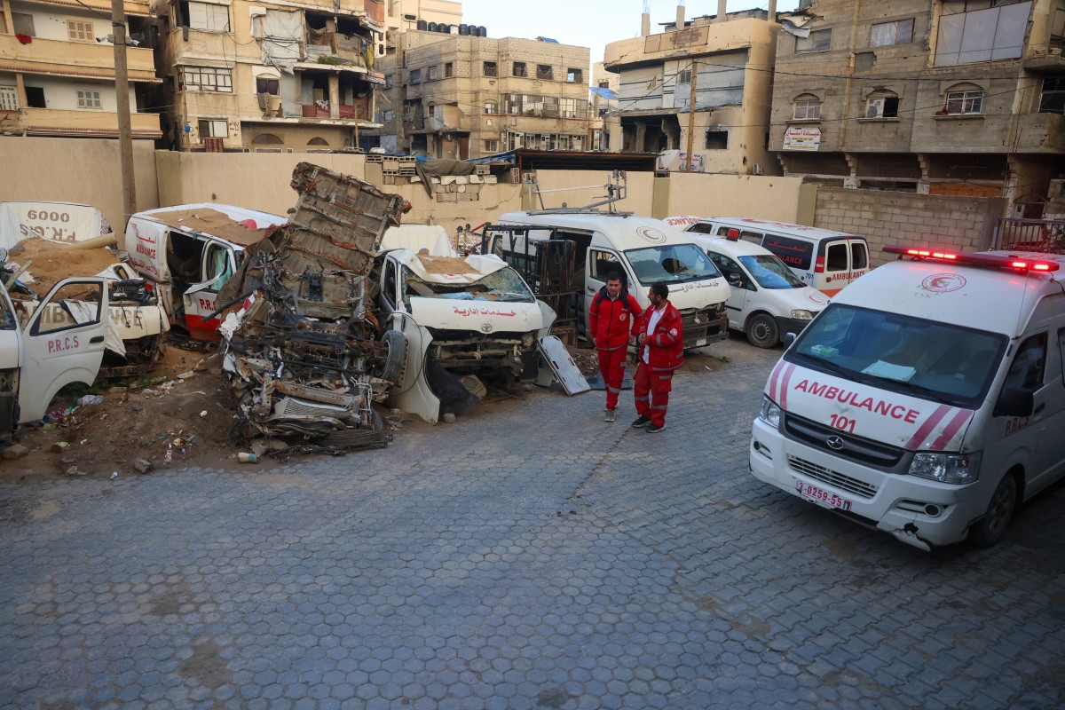 Palestinian paramedics walk past destroyed ambulances at the headquarters of the Palestinian Red Crescent Society in Khan Yunis, in the southern Gaza Strip, Feb. 24, 2026. (AFP)