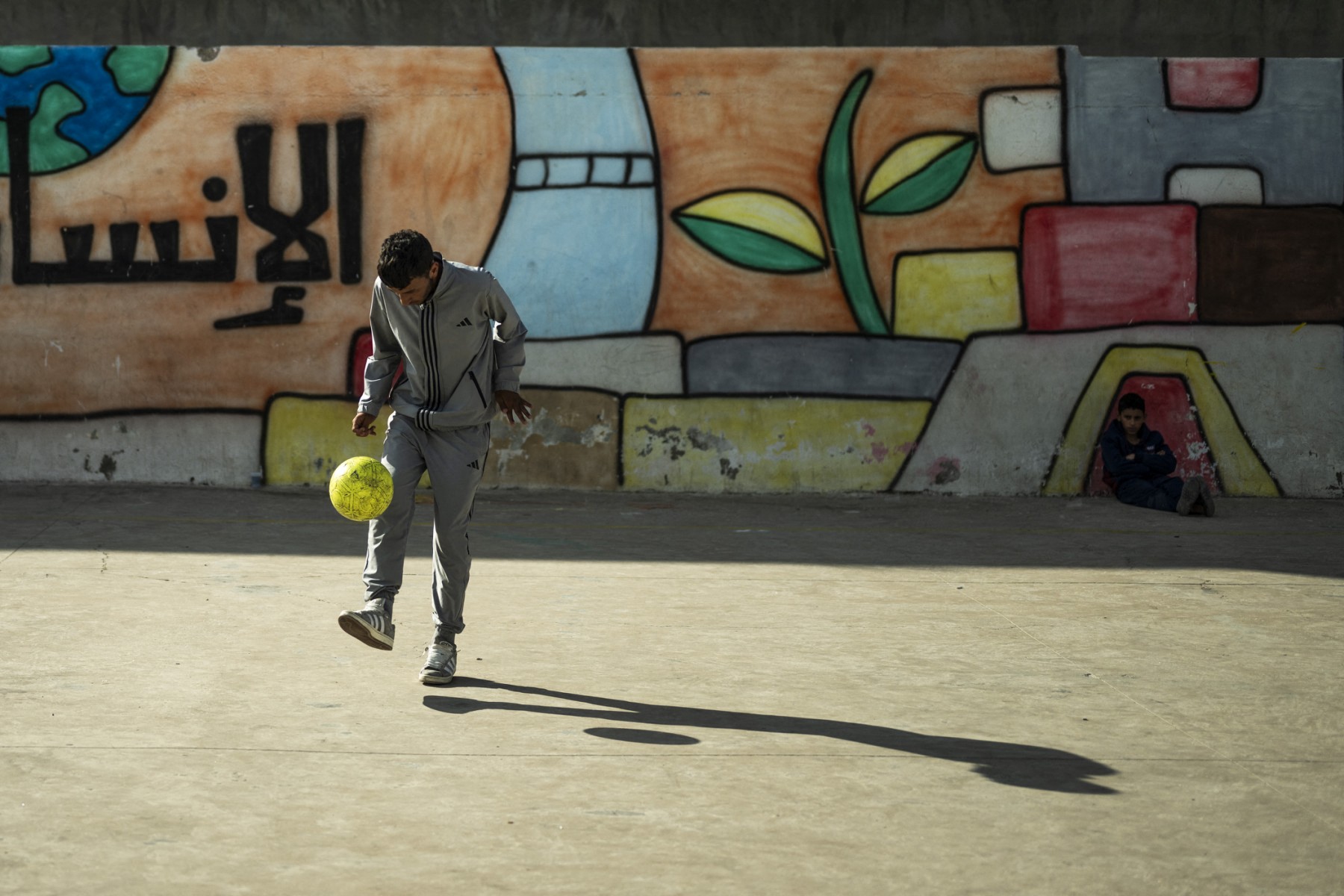 A student plays with a football in the courtyard of the UNRWA school at Al-Wehdat refugee camp in Amman, May 24, 2026. (AFP)