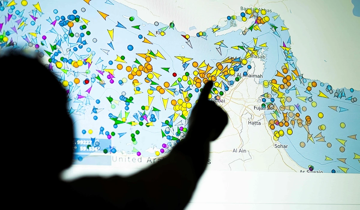 A person in front of a large screen displaying vessel movements in the Strait of Hormuz on a ship-tracking website. (AFP)