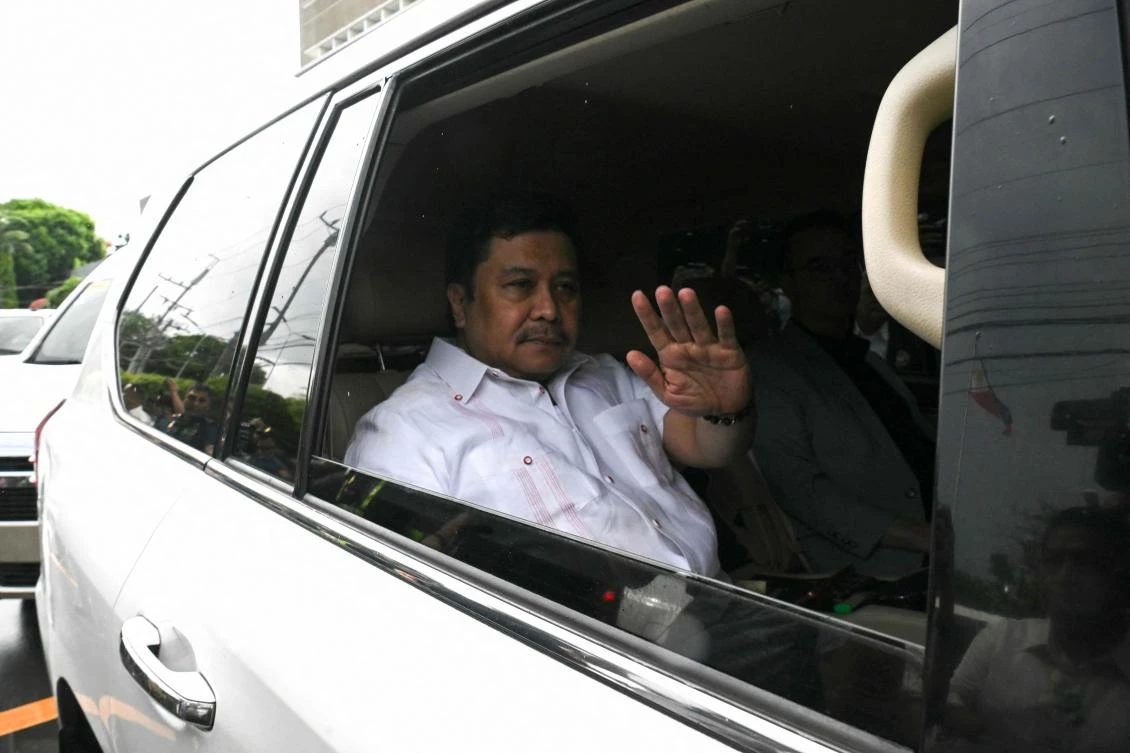 Philippine Senator Jose Jinggoy Estrada waves to photographers from inside his car as he heads to the national police headquarters to surrender on June 1, 2026. (AFP)