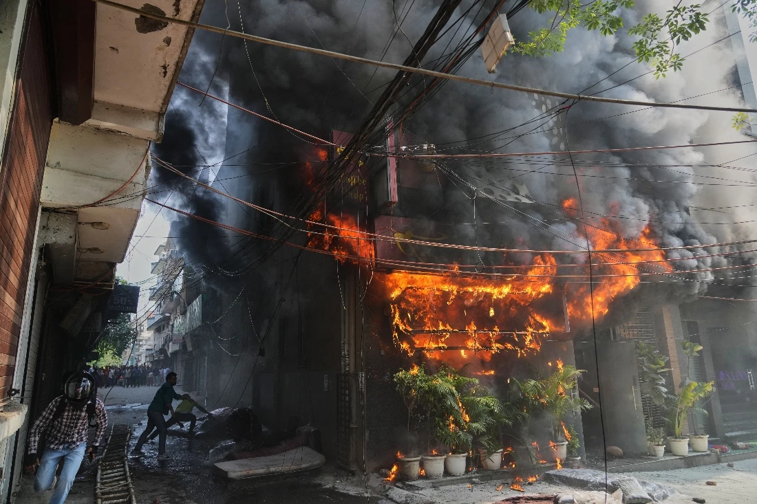Local people attempt to douse a fire at a hotel in New Delhi, India. (AP)