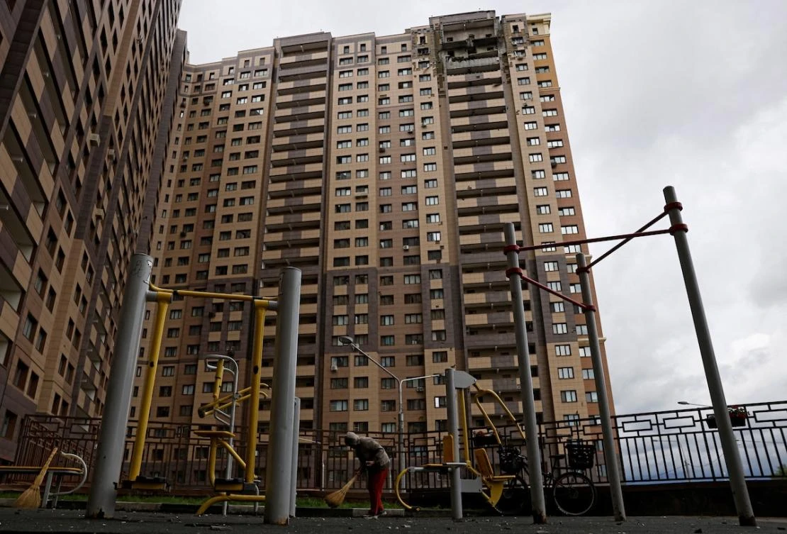 A person sweeps up debris in front of a damaged apartment building following an earlier Ukrainian drone attack in the Moscow region on June 18, 2026. (Reuters file photo)