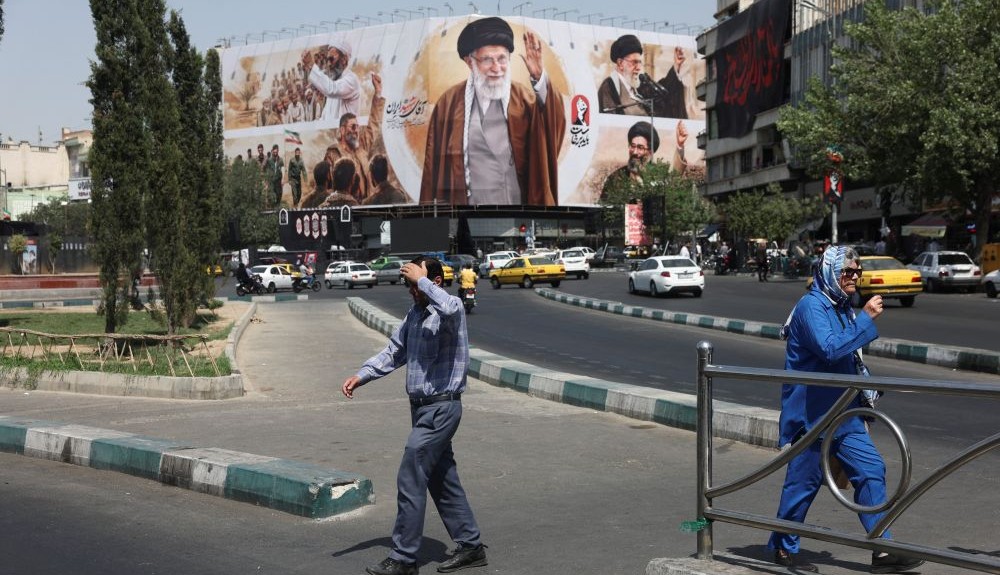 People walk past a billboard featuring images of Ayatollah Ali Khamenei, Tehran, Iran, July 13, 2026. (Reuters)