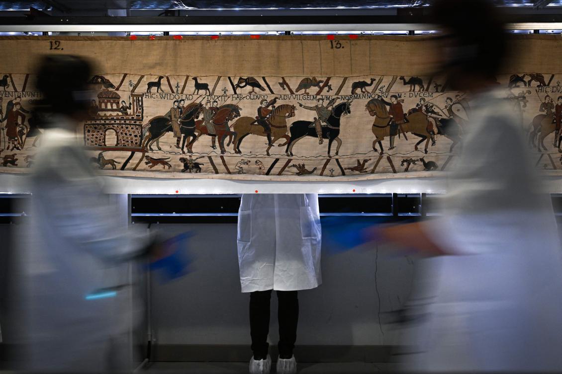 Workers and volunteers, rest before preparing to pack the Bayeux Tapestry in a crate for transfer to the British Museum, at the Bayeux Tapestry Museum, in northwestern France. (AFP/File)