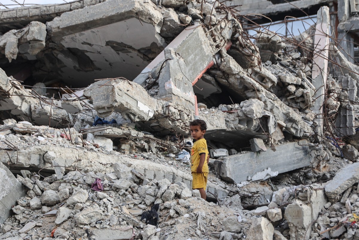 A Palestinian child stands on the rubble of a destroyed building near the al-Shati refugee camp, west of Gaza City. (AFP)